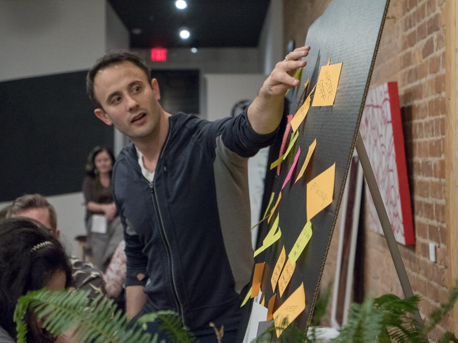 A participant places sticky notes on a board