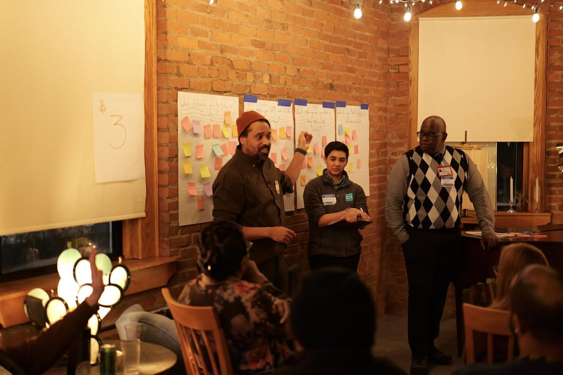 Facilitators at boards of sticky notes in a café