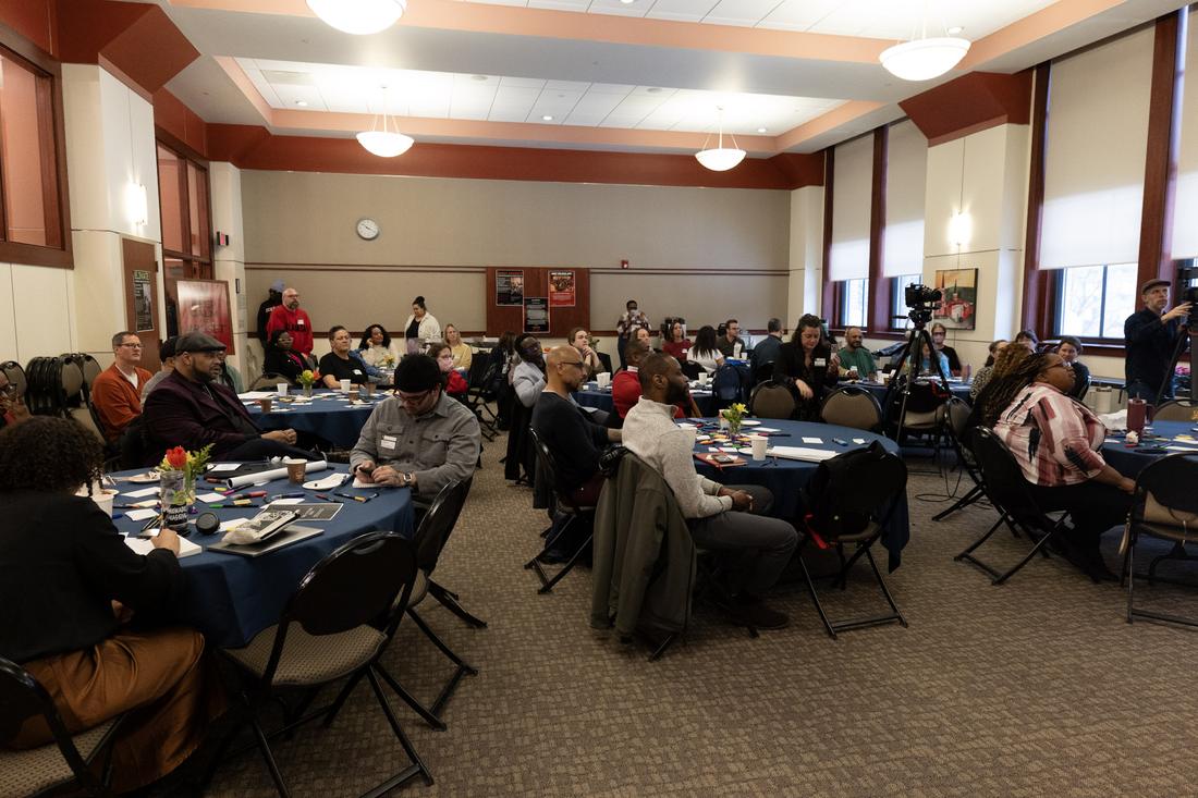 A conference hall full of round tables mid-session